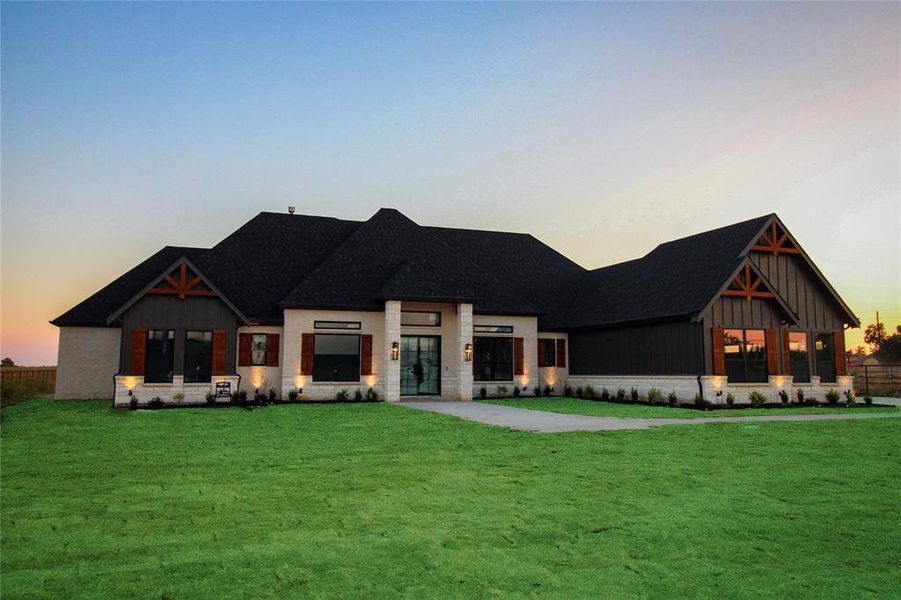 Modern inspired farmhouse with board and batten siding and a front lawn