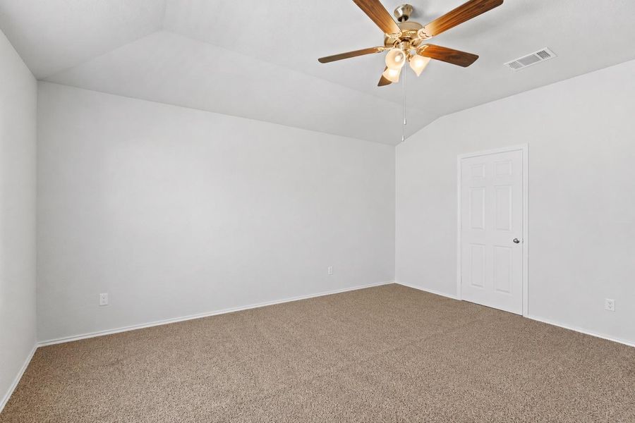 A spacious room features plush carpet flooring and a tasteful ceiling fan, awaiting your personal touch. A spacious room features plush carpet flooring and a tasteful ceiling fan, awaiting your personal touch.
