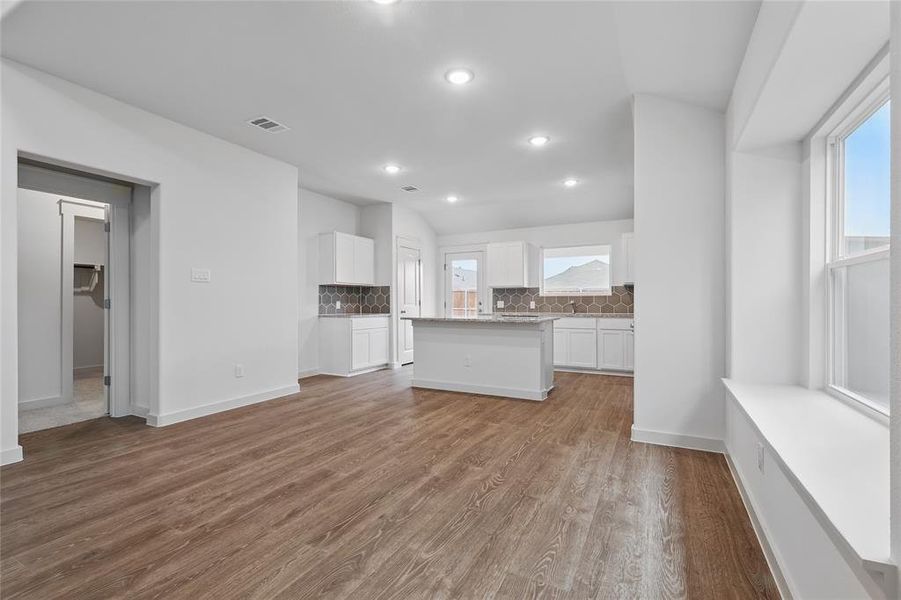 Unfurnished living room with visible vents, a healthy amount of sunlight, recessed lighting, and wood finished floors Unfurnished living room with visible vents, a healthy amount of sunlight, recessed lighting, and wood finished floors