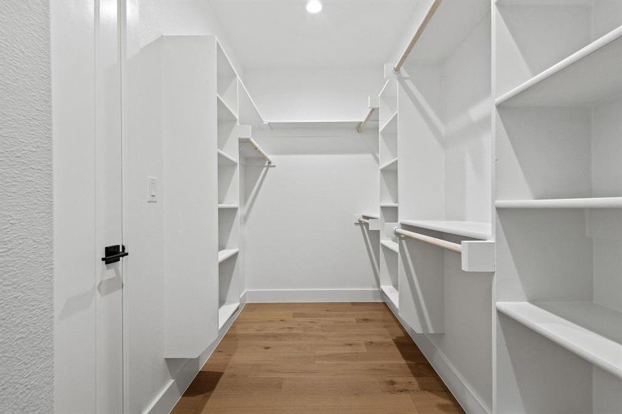 Walk in closet with light wood finished floors