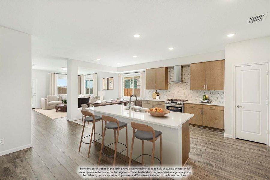 Open-concept kitchen with large island, wood cabinets, and hardwood floors, open to dining and living areas