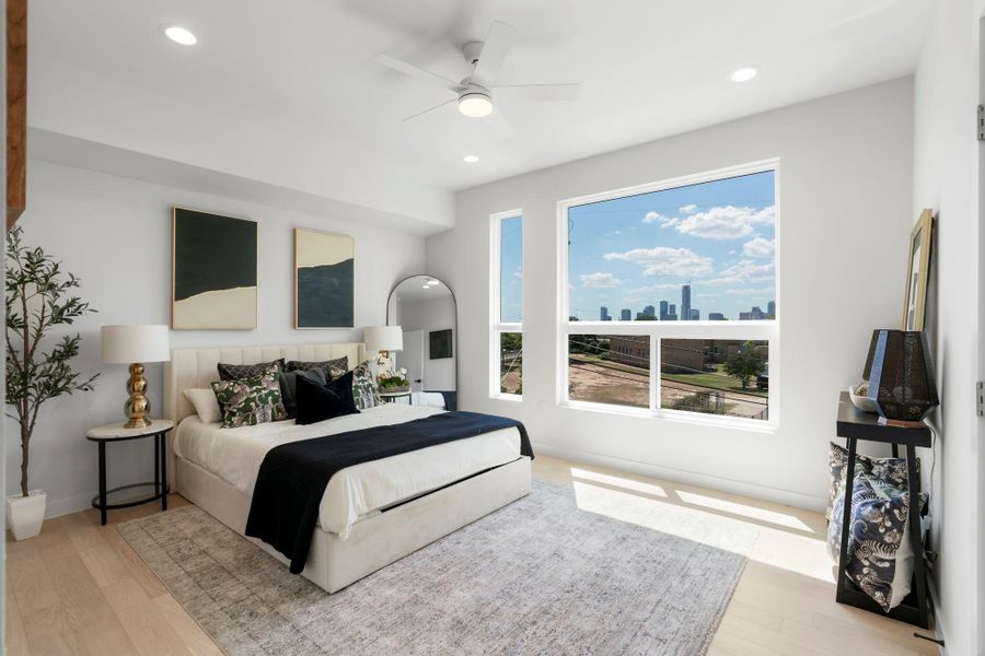 Bedroom with light wood finished floors, a ceiling fan, a skyline view, and recessed lighting