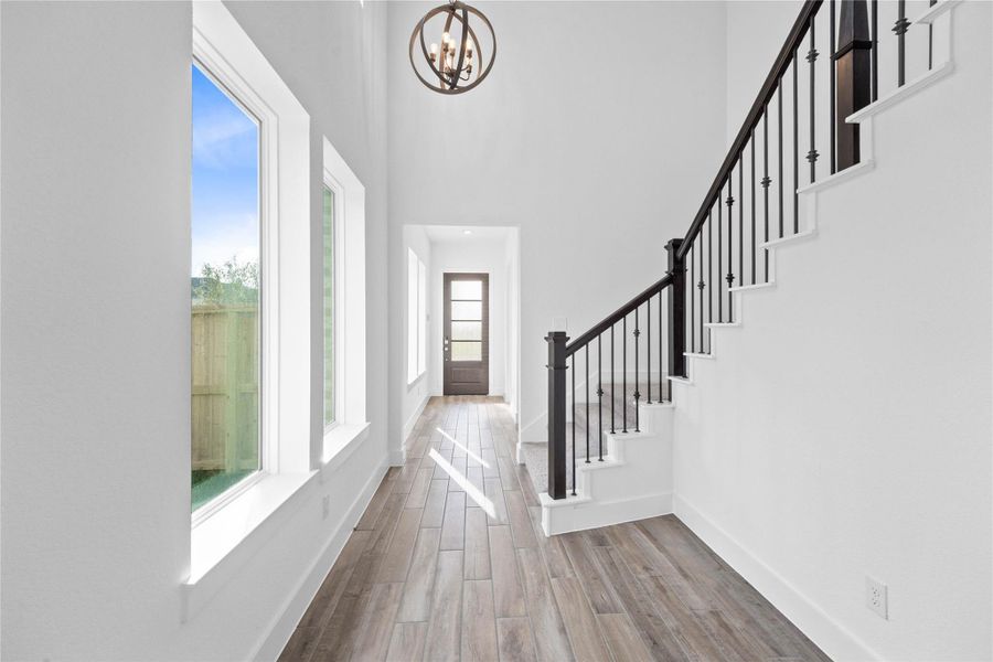 As you enter the home, you are greeted by a wall of windows that floods the space with abundant natural lighting.