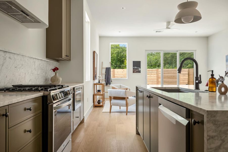 Culinary creativity awaits in this pristine kitchen with rich cabinetry and luminous countertops, opening to a private outdoor oasis.