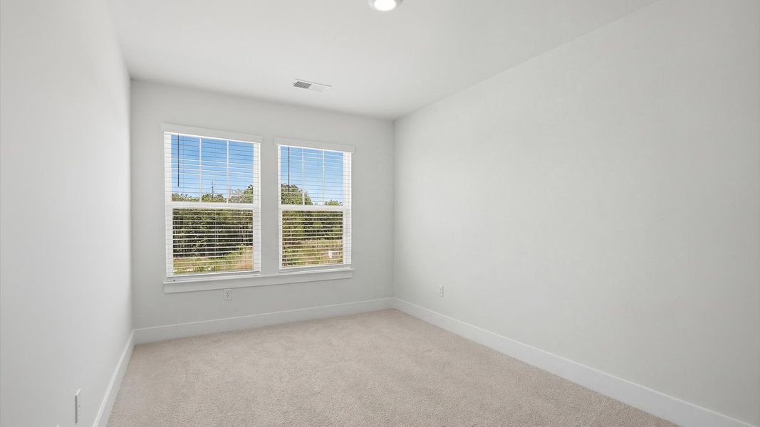 Vibrant and restful bedroom with oversized windows, refined detail, and a warm, welcoming atmosphere by DRB Homes Vibrant and restful bedroom with oversized windows, refined detail, and a warm, welcoming atmosphere by DRB Homes