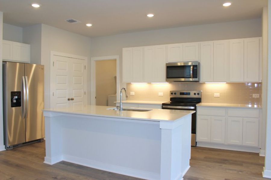 A kitchen with white cabinets.