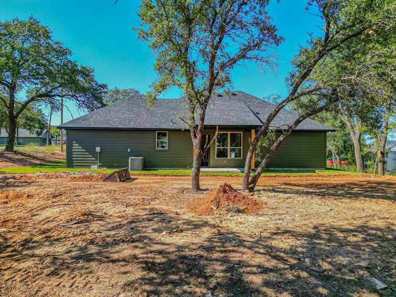 Back of house with a patio and roof with shingles
