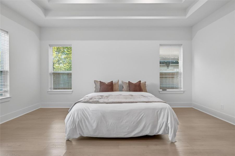 The primary bedroom offers plenty of space for a full furniture arrangement with windows overlooking the property. **Images are from a previously completed project. **