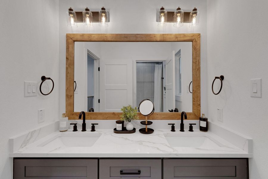 Secondary bath with dual sinks, quartz counters, and matte black fixtures for a sleek, modern look. Secondary bath with dual sinks, quartz counters, and matte black fixtures for a sleek, modern look.