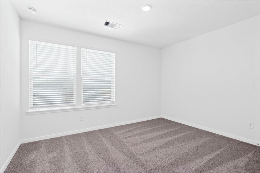 This secondary bedroom offers comfort and style with plush carpeting, neutral paint tones, recessed lighting, large windows with blinds, and a generously sized closet. This secondary bedroom offers comfort and style with plush carpeting, neutral paint tones, recessed lighting, large windows with blinds, and a generously sized closet.