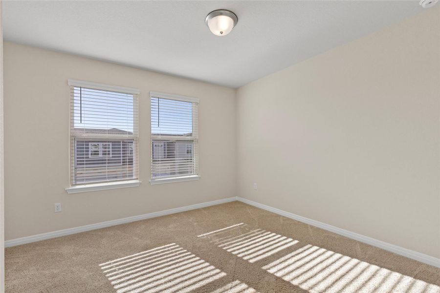 Unfurnished bedroom featuring baseboards and light carpet Unfurnished bedroom featuring baseboards and light carpet