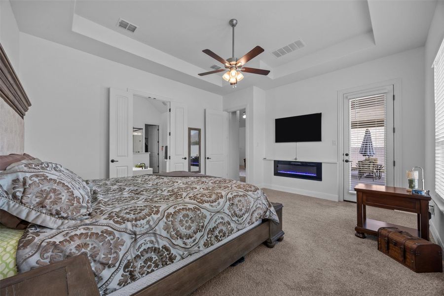 Relax in this primary suite featuring a fireplace, tray ceiling, and a private exit door. Relax in this primary suite featuring a fireplace, tray ceiling, and a private exit door.
