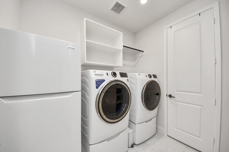 Dedicated laundry space with shelving and storage area.