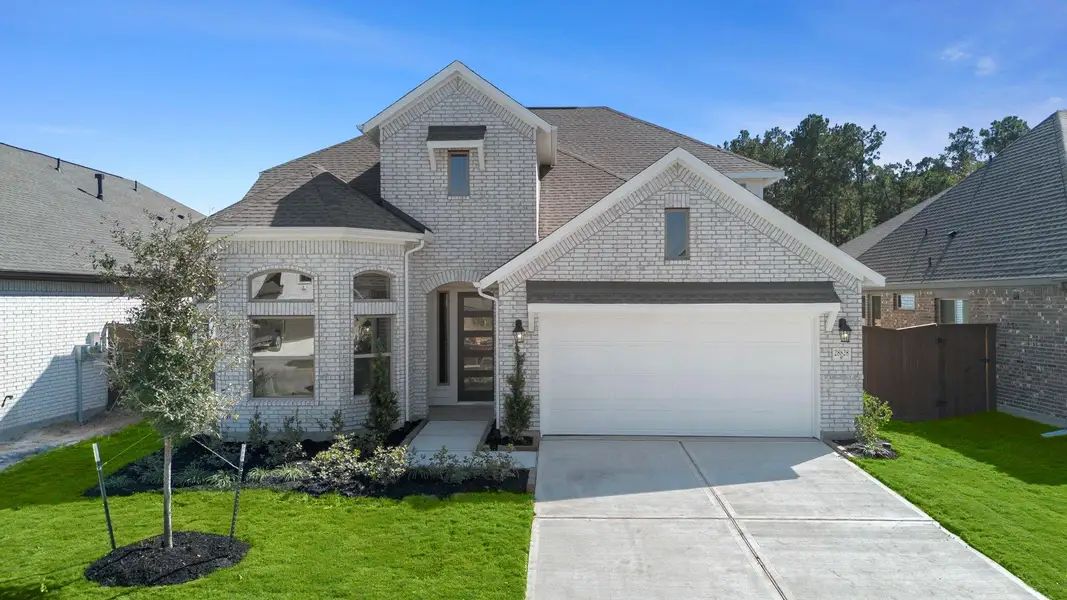Front exterior of a new home in The Trails, New Caney, TX, highlighting curb appeal (Image 1).