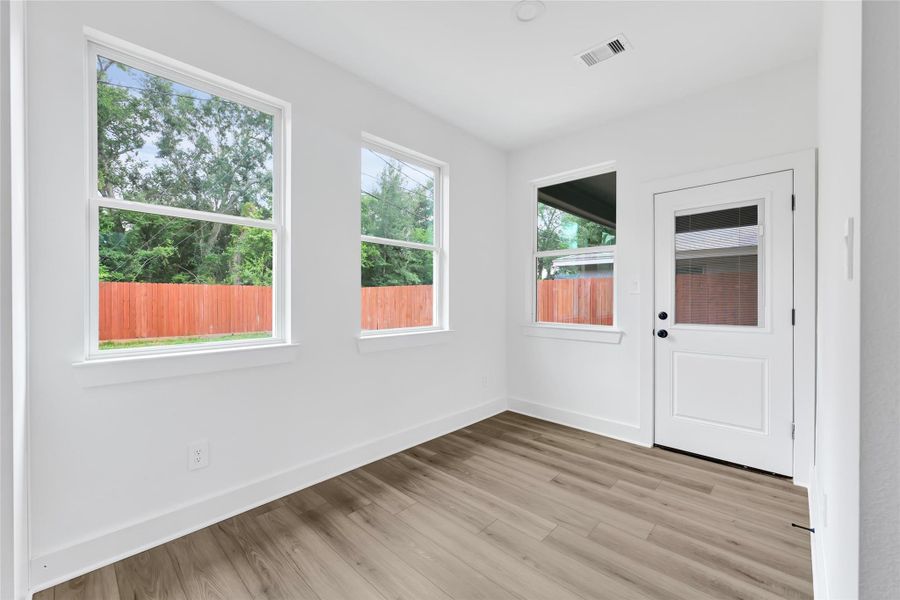 Kitchen and dining area filled with light from large windows. Kitchen and dining area filled with light from large windows.