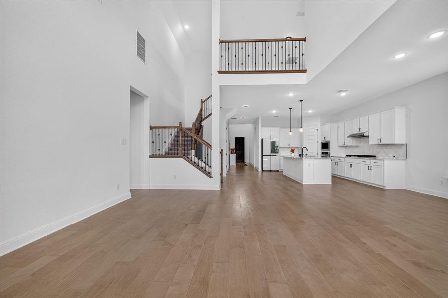 Warm wood flooring and high ceilings define this airy, open-concept living space. Warm wood flooring and high ceilings define this airy, open-concept living space.