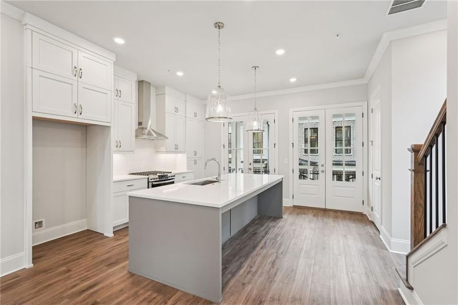 Two tone kitchen featuring french doors, pendant lighting, backsplash, crown molding, and dark wood-style floors