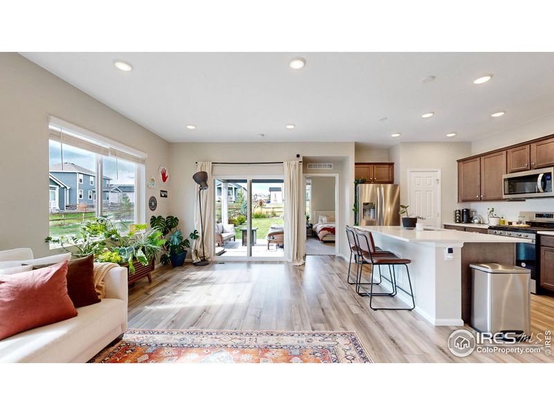 Open concept floor plan featuring LVP flooring, a gas fireplace in the living space and a walk-out patio.