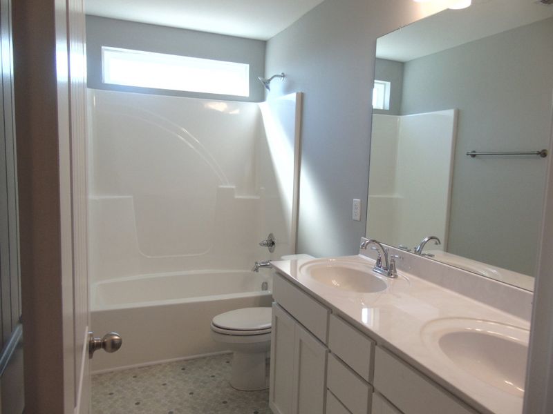 The second bath is a tub shower combo, includes two sleek sinks, as well as an elongated toilet, an elongated toilet, and plenty of cabinet space.
