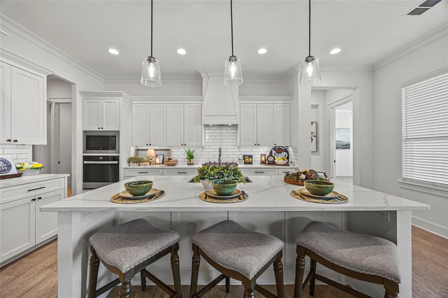 Kitchen with decorative backsplash, built in microwave, hardwood / wood-style flooring, and oven