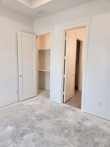 Front Secondary bedroom featuring a walk in closet