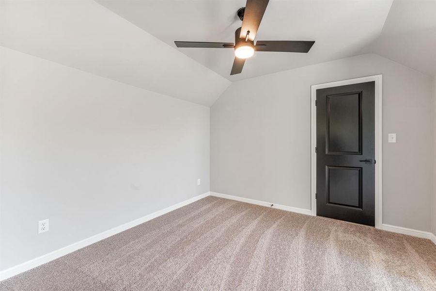 Additional living space featuring lofted ceiling, ceiling fan, and carpet floors