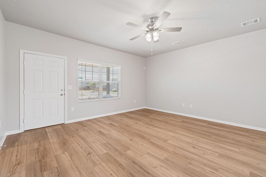 Empty room with light wood finished floors and a ceiling fan Empty room with light wood finished floors and a ceiling fan