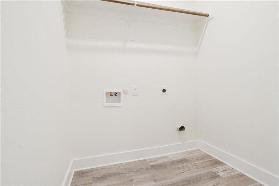Laundry area featuring  wood- style finished floors, hookup for an electric dryer, hookup for a washing machine, and gas dryer hookup
