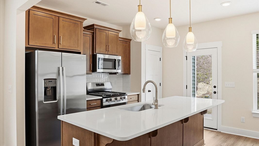 Tasteful kitchen with a center island and stylish pendant lighting—crafted to high standards located at Marion Square Tasteful kitchen with a center island and stylish pendant lighting—crafted to high standards located at Marion Square