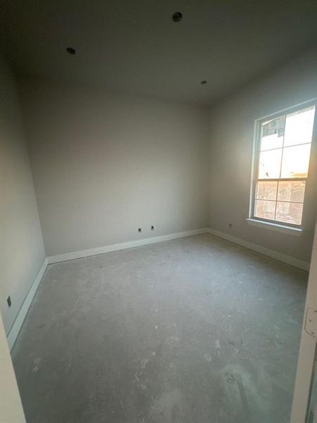 Unfurnished room featuring concrete flooring and baseboards
