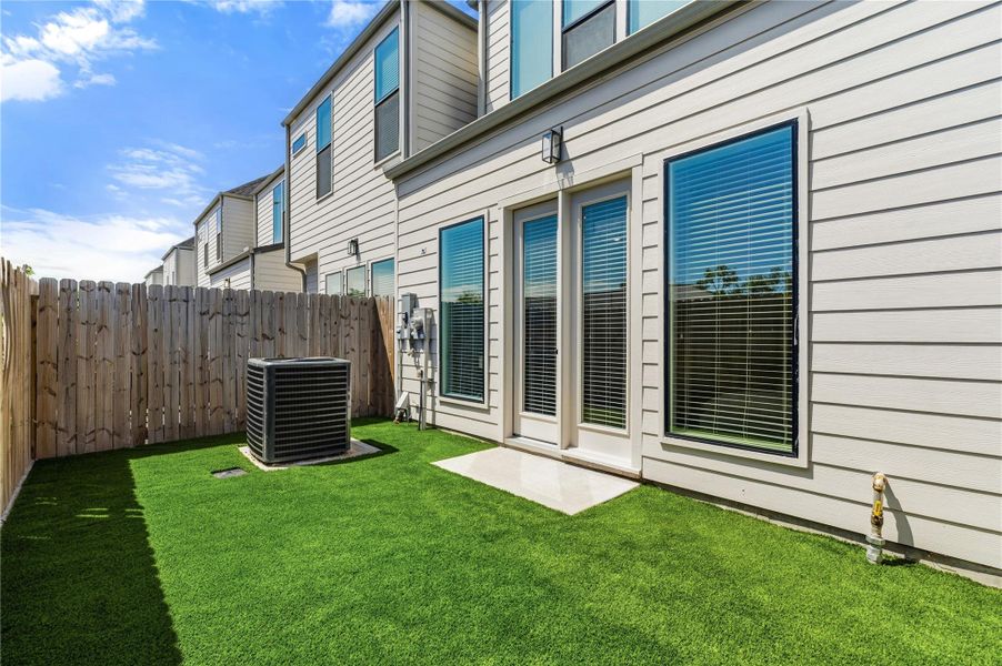 Private backyard with artificial turf, offering a clean and low-maintenance outdoor space year-round. Private backyard with artificial turf, offering a clean and low-maintenance outdoor space year-round.