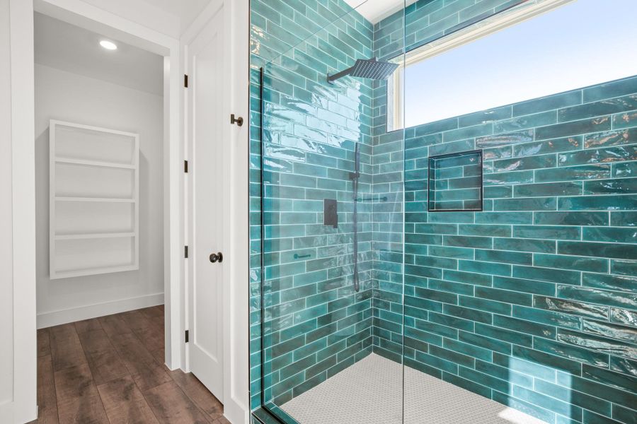 Bathroom featuring tiled shower and dark wood finished floors