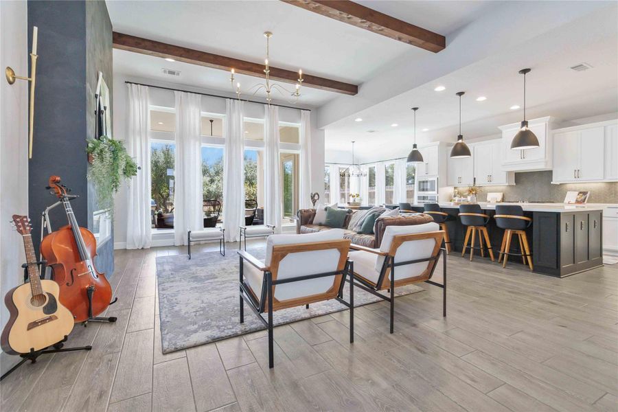 Living room with a chandelier, beam ceiling, recessed lighting, and light wood-style flooring Living room with a chandelier, beam ceiling, recessed lighting, and light wood-style flooring