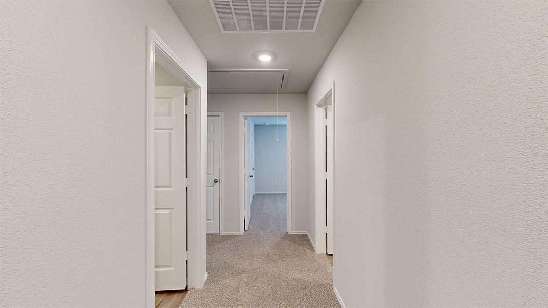 Hall featuring light colored carpet, a textured wall, and recessed lighting