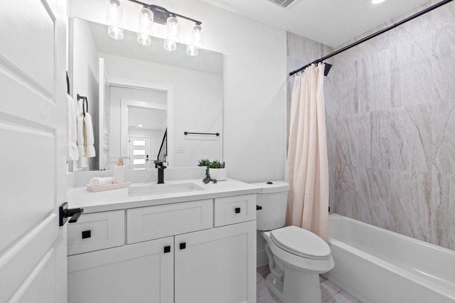 Bathroom featuring vanity, shower / tub combo, and recessed lighting