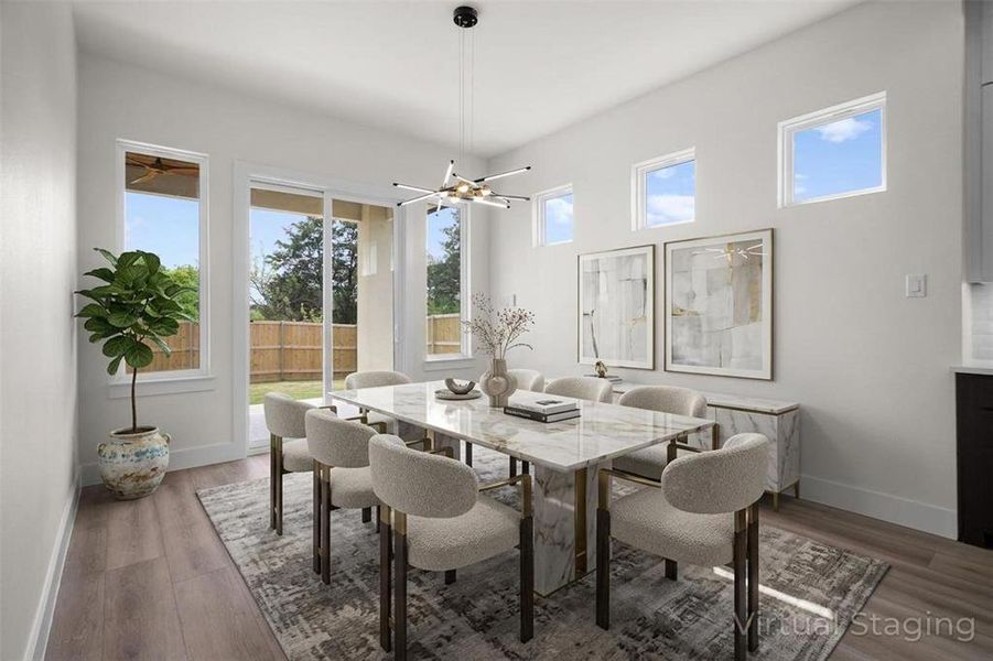 The dining area features light wood-style flooring and abundant natural light from several windows, including a large sliding glass door The dining area features light wood-style flooring and abundant natural light from several windows, including a large sliding glass door