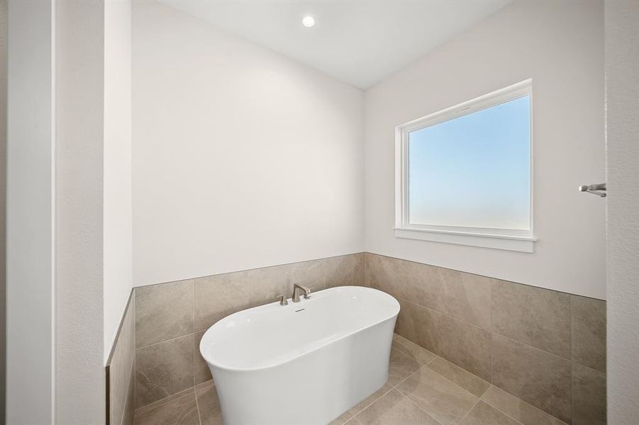 Full bathroom with tile walls, a freestanding tub, wainscoting, recessed lighting, and tile patterned floors