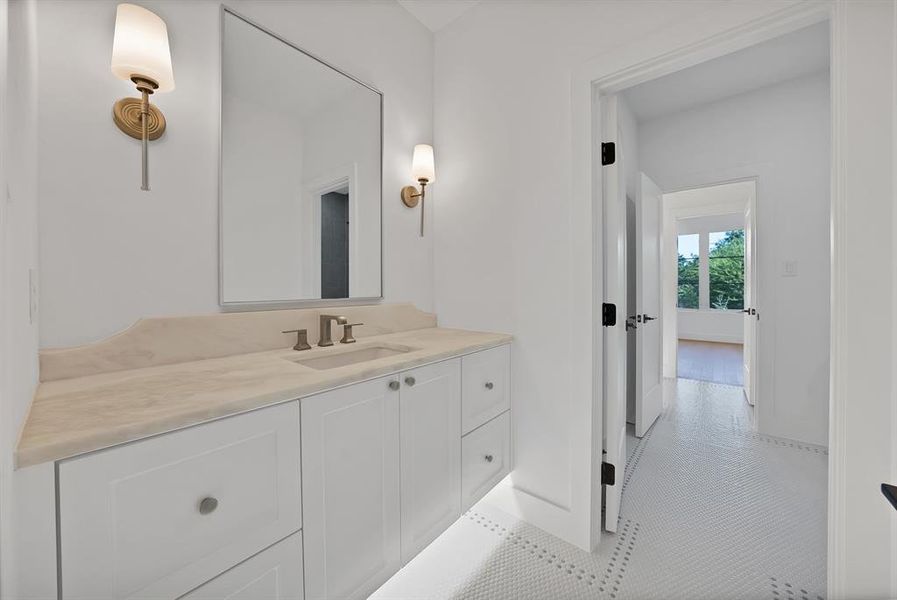 Bathroom featuring a single vanity with a light-toned countertop, integrated sink, and brushed nickel faucet