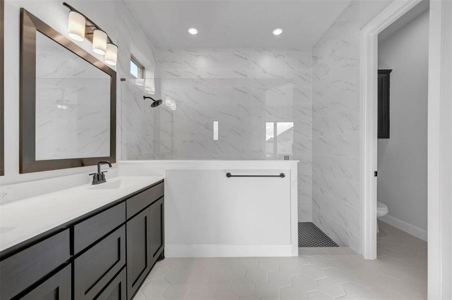 Full bath with double vanity, a marble finish shower, light tile patterned flooring, and recessed lighting Full bath with double vanity, a marble finish shower, light tile patterned flooring, and recessed lighting