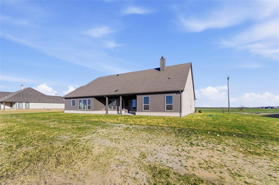 Back of property featuring a patio area, a yard, and a chimney