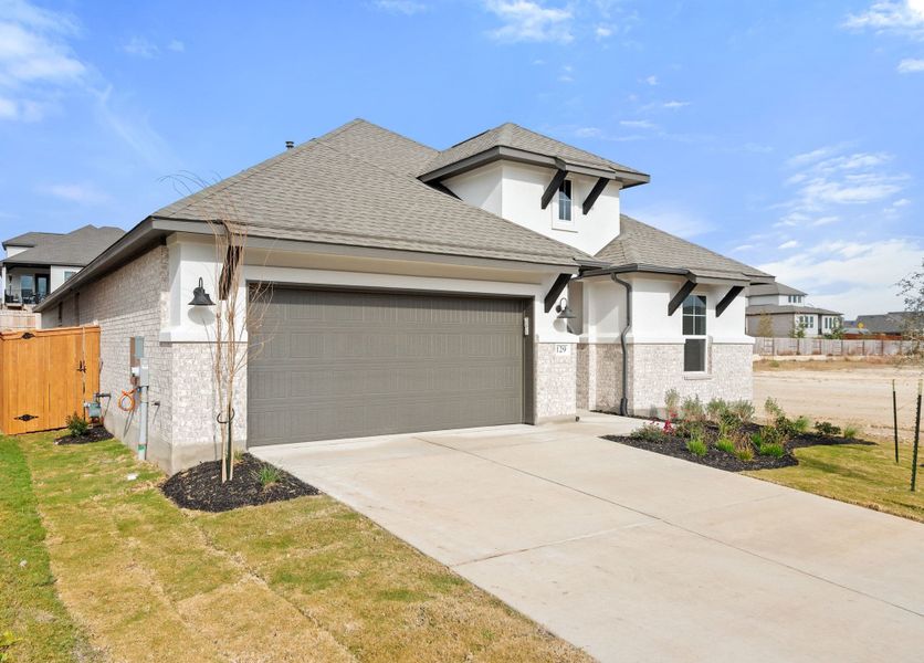 Front exterior of a new home in Lariat, Liberty Hill, TX, highlighting curb appeal (Image 2). Front exterior of a new home in Lariat, Liberty Hill, TX, highlighting curb appeal (Image 2).