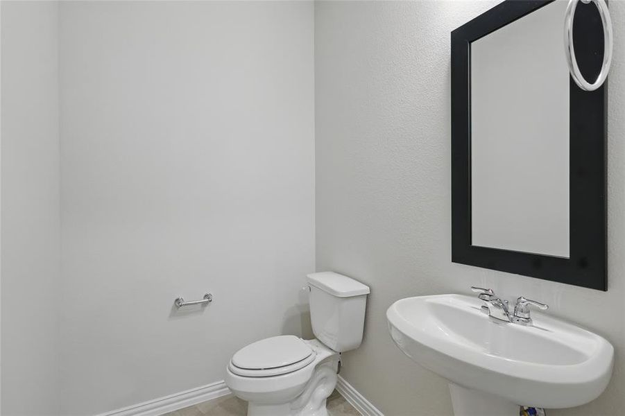 Half bath featuring toilet and a sink