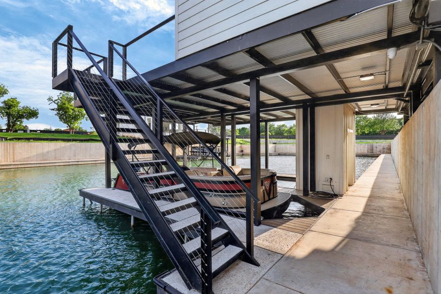 A private boat dock and sturdy metal staircase offer seamless water access and convenience. A private boat dock and sturdy metal staircase offer seamless water access and convenience.