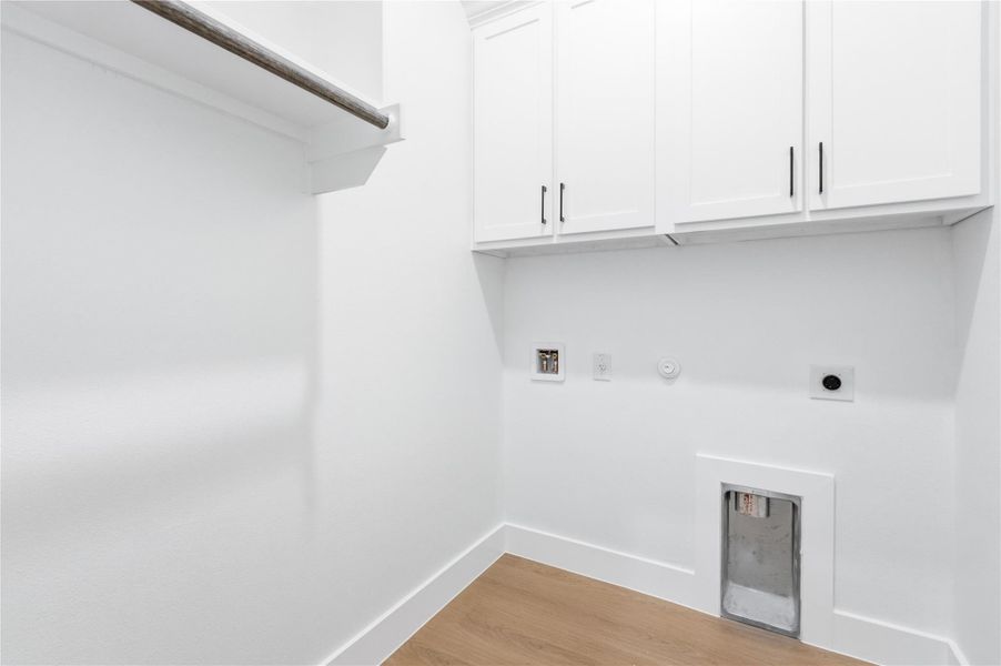 Laundry area with gas dryer hookup, light wood-type flooring, hookup for a washing machine, hookup for an electric dryer, and cabinet space