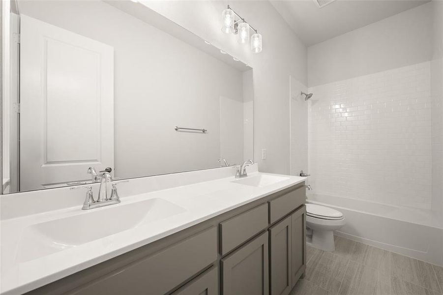 Full bath with toilet, double vanity, and bathtub / shower combination Full bath with toilet, double vanity, and bathtub / shower combination