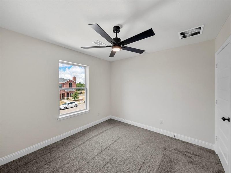 Spare room featuring ceiling fan and carpet