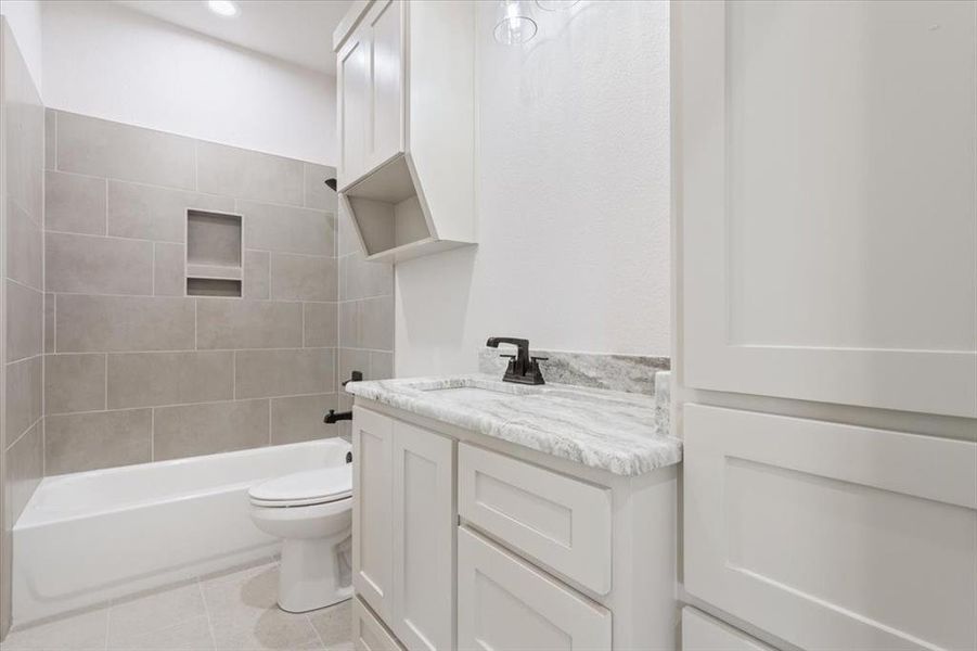 Bathroom with shower / bathtub combination, vanity, and light tile patterned flooring