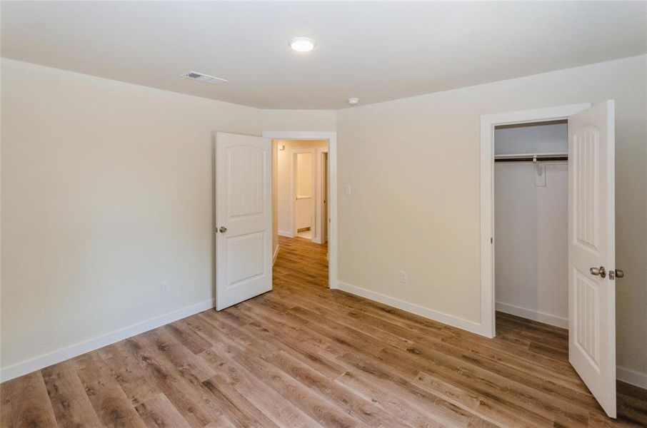 Unfurnished bedroom featuring light wood-type flooring and a closet