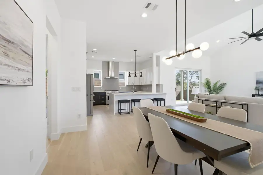 Dining room featuring light wood-type flooring, a ceiling fan, and hanging lights