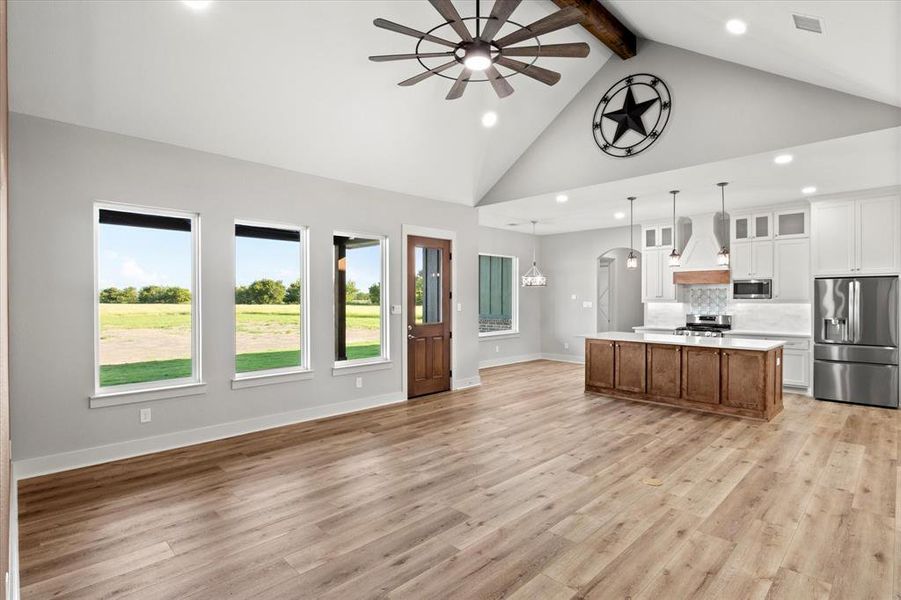 Kitchen featuring ceiling fan, white cabinetry, appliances with stainless steel finishes, glass insert cabinets, and open floor plan Kitchen featuring ceiling fan, white cabinetry, appliances with stainless steel finishes, glass insert cabinets, and open floor plan